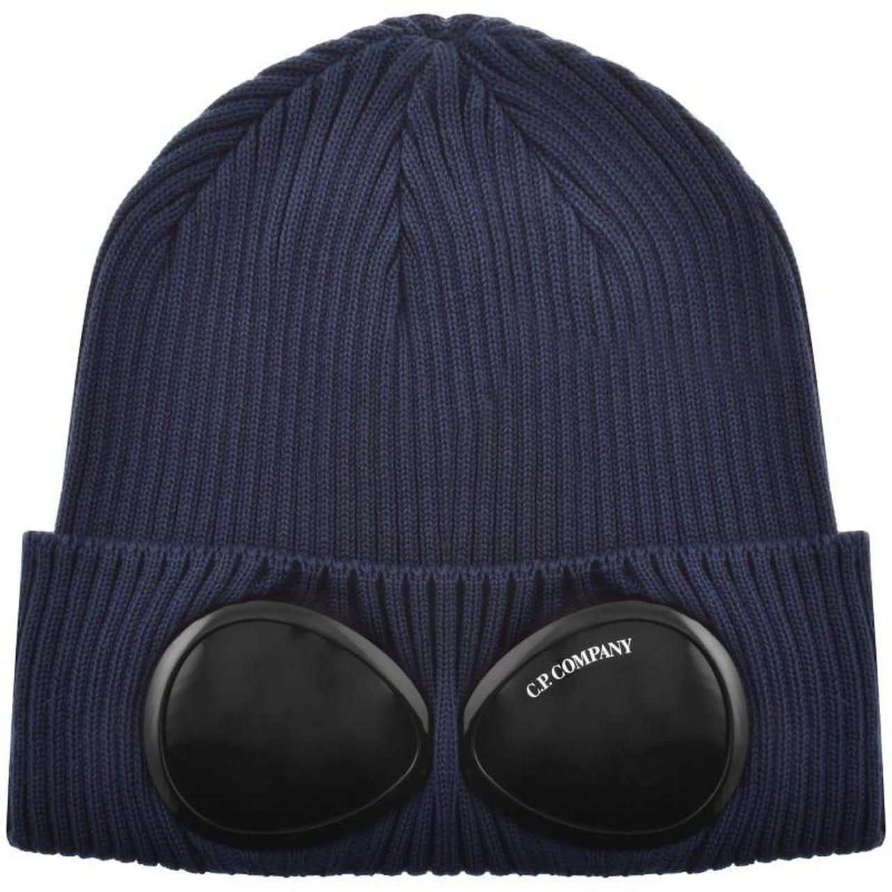 CP Company navy blue beanie hat with goggle detail and cotton material.