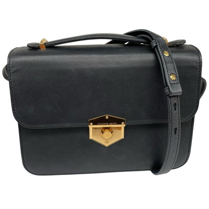 Alexander McQueen black and gold leather messenger bag with logo detailing and faint scratches.