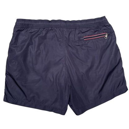 Moncler navy blue swim shorts with logo patch and lightweight nylon material.