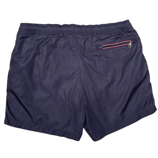 Moncler navy blue swim shorts with logo patch and lightweight nylon material.