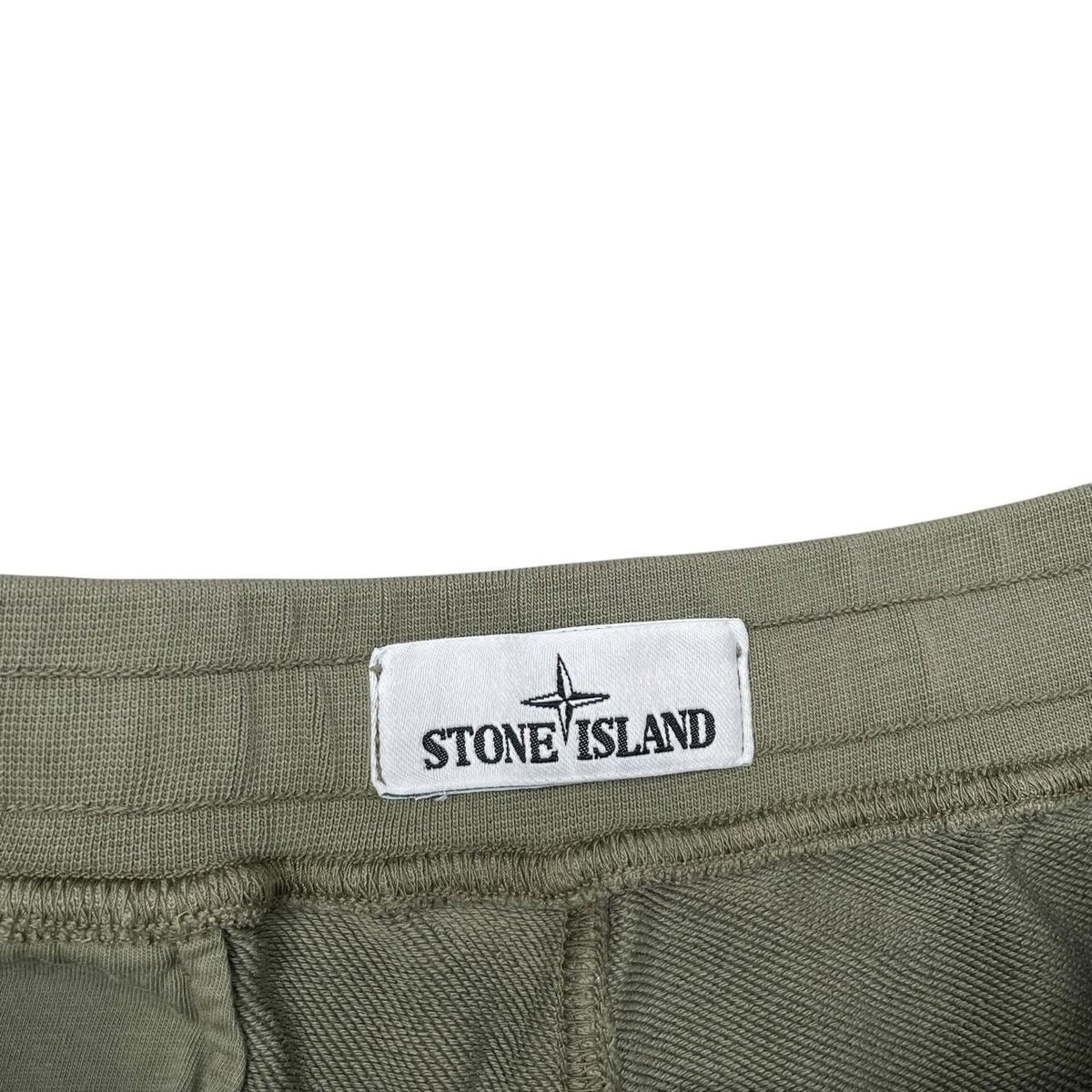 Stone Island green jogger shorts with logo patch and cotton material.