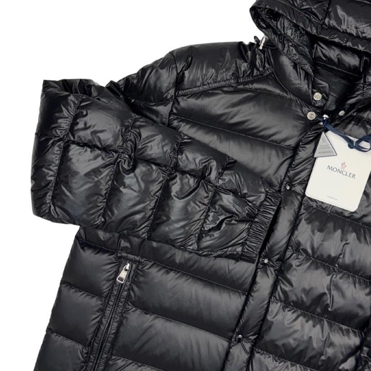Moncler black hooded puffer jacket with logo patch and nylon material.
