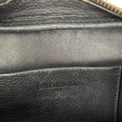 Balenciaga black leather messenger bag with embossed logo and minimalistic design.