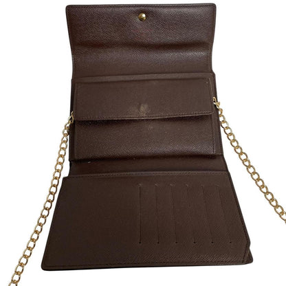 Louis Vuitton gold crossbody wallet Damier Ebene canvas with removable strap and logo.