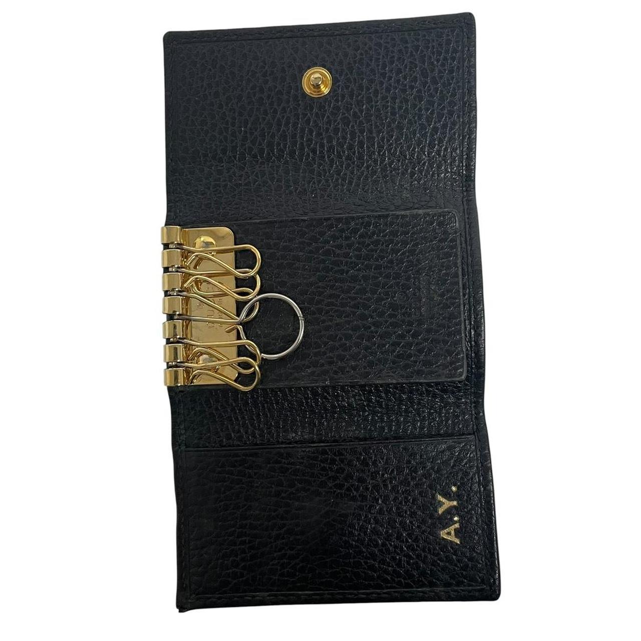 Gucci black leather key case with GG logo and quilted pattern.