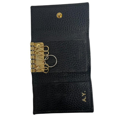 Gucci black leather key case with GG logo and quilted pattern.