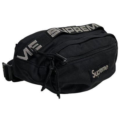 Supreme black waist bag featuring logo print and durable material.