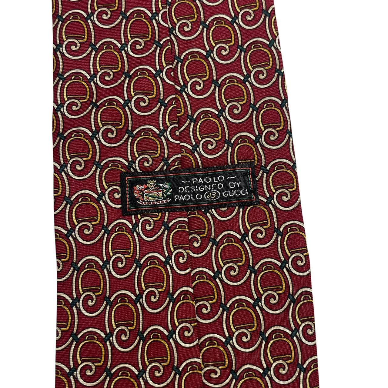 Gucci burgundy silk tie with vintage pattern and signature logo detail.
