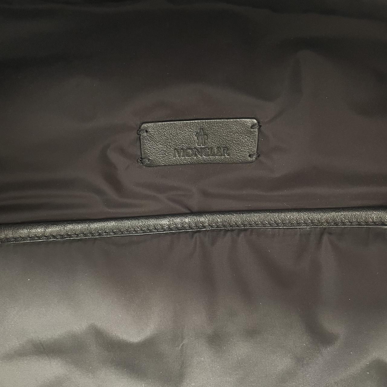 Moncler black duffel bag with logo patch and durable material, pre-loved condition.