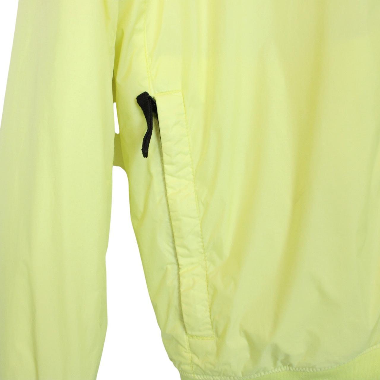 Stone Island yellow jacket with crinkle texture and logo badge on sleeve.