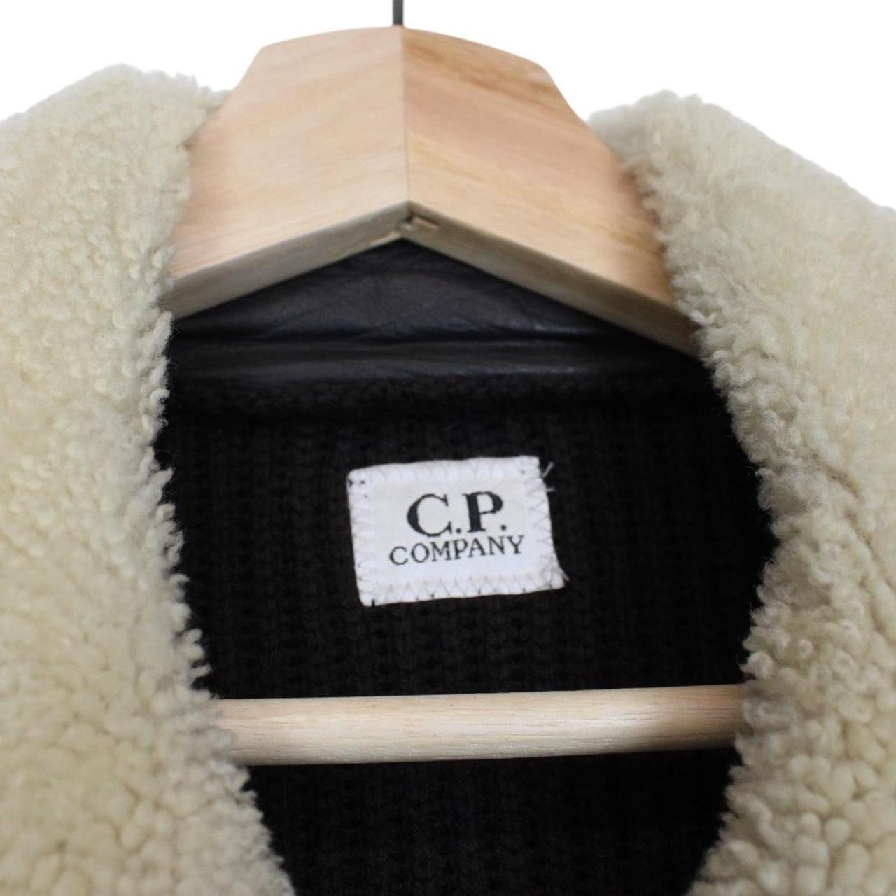 CP Company brown leather and wool shearling jacket with vintage design and logo details.