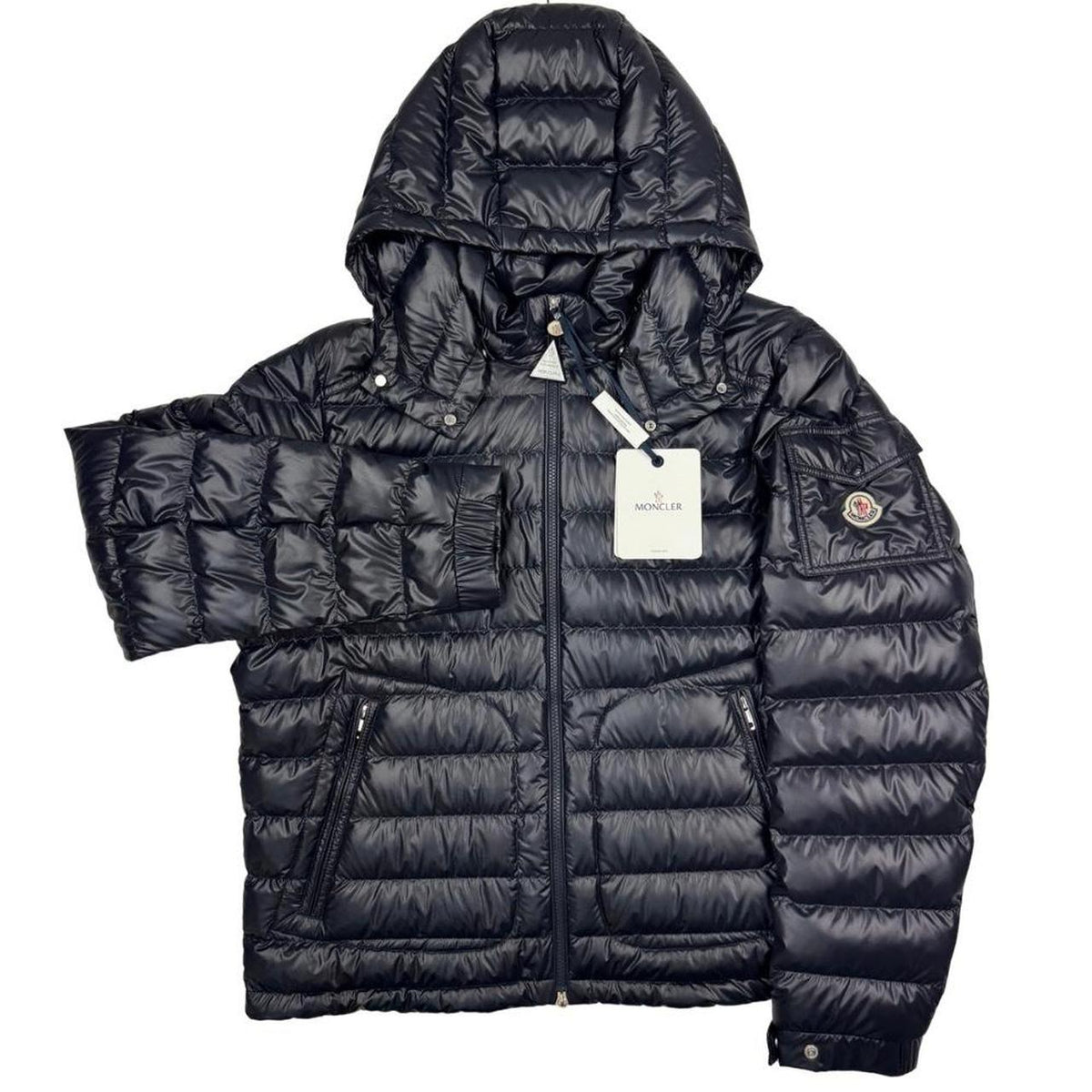 Moncler navy blue hooded puffer jacket with logo patch and nylon material.