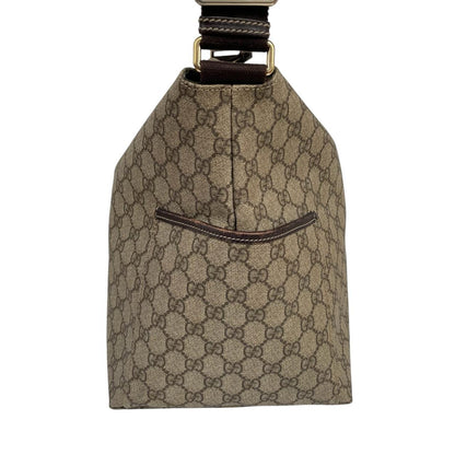 Gucci brown diaper changing bag with Supreme GG monogram and leather shoulder strap.