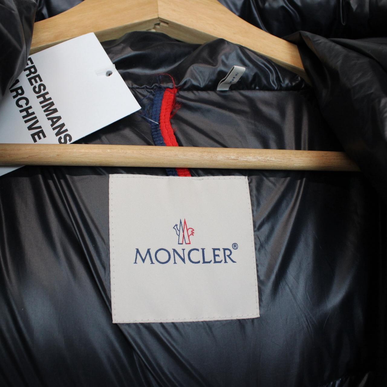 Moncler navy blue hooded nylon down gilet with logo and quilted texture.