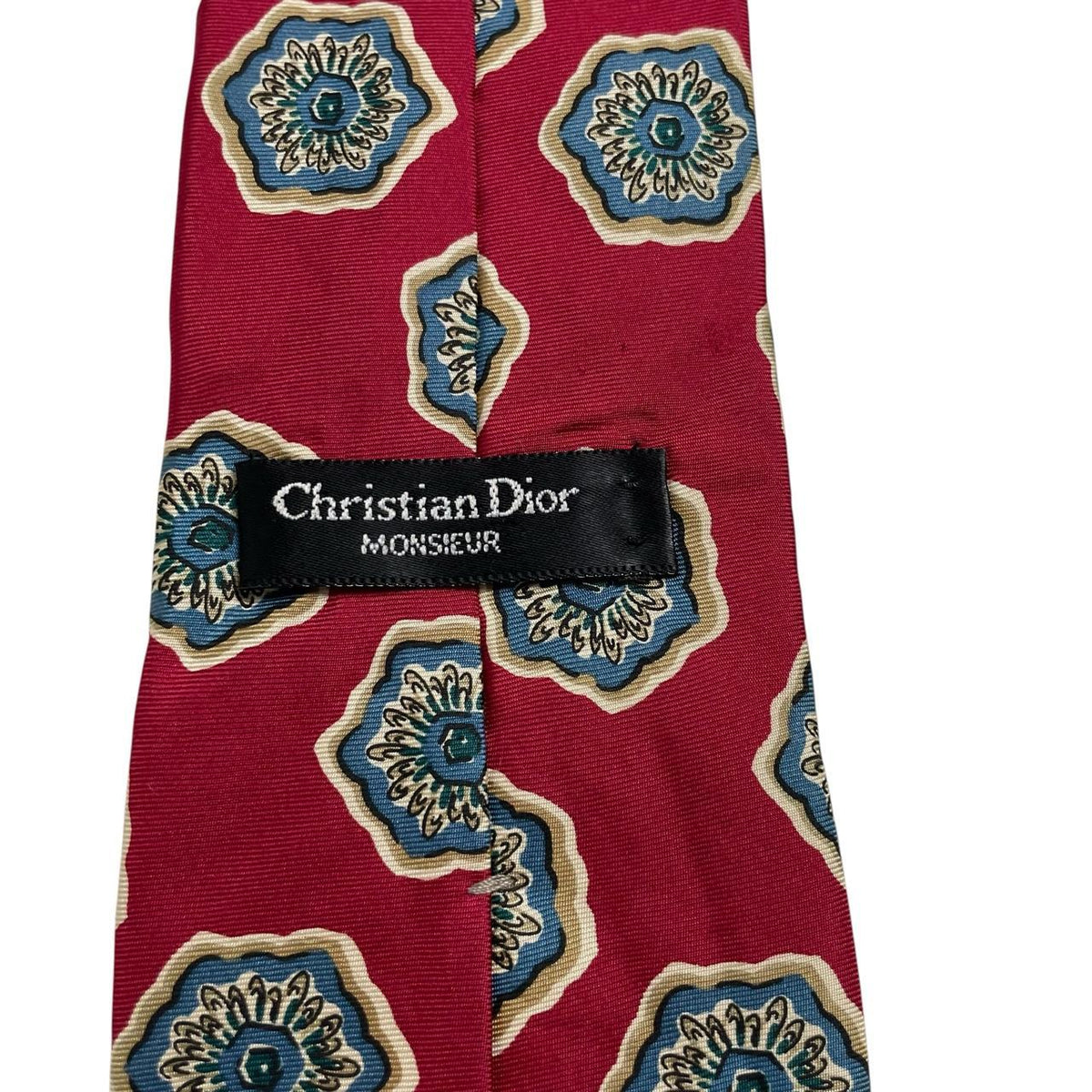 Christian Dior red silk tie with geometric pattern and logo detail.