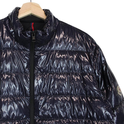 Moncler navy blue full zip down jacket with logo patch and quilted material.