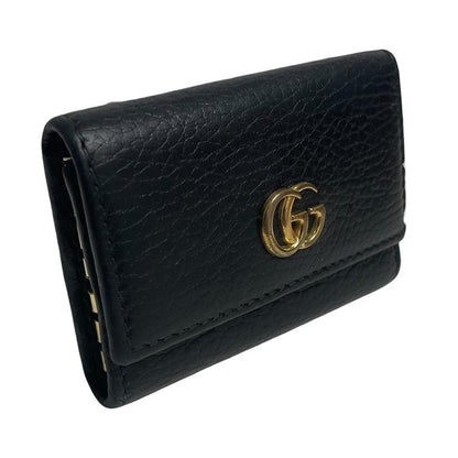 Gucci black leather key case with GG logo and quilted pattern.