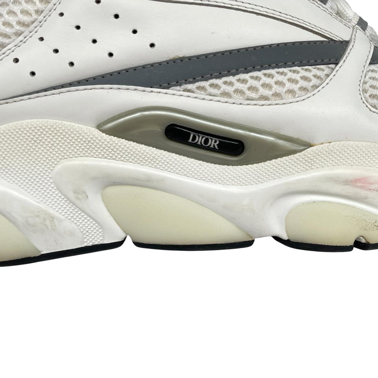 Dior grey and white trainers with logo detailing and worn soles.
