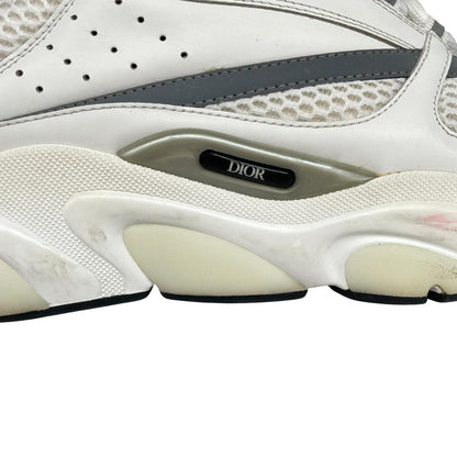 Dior grey and white trainers with logo detailing and worn soles.