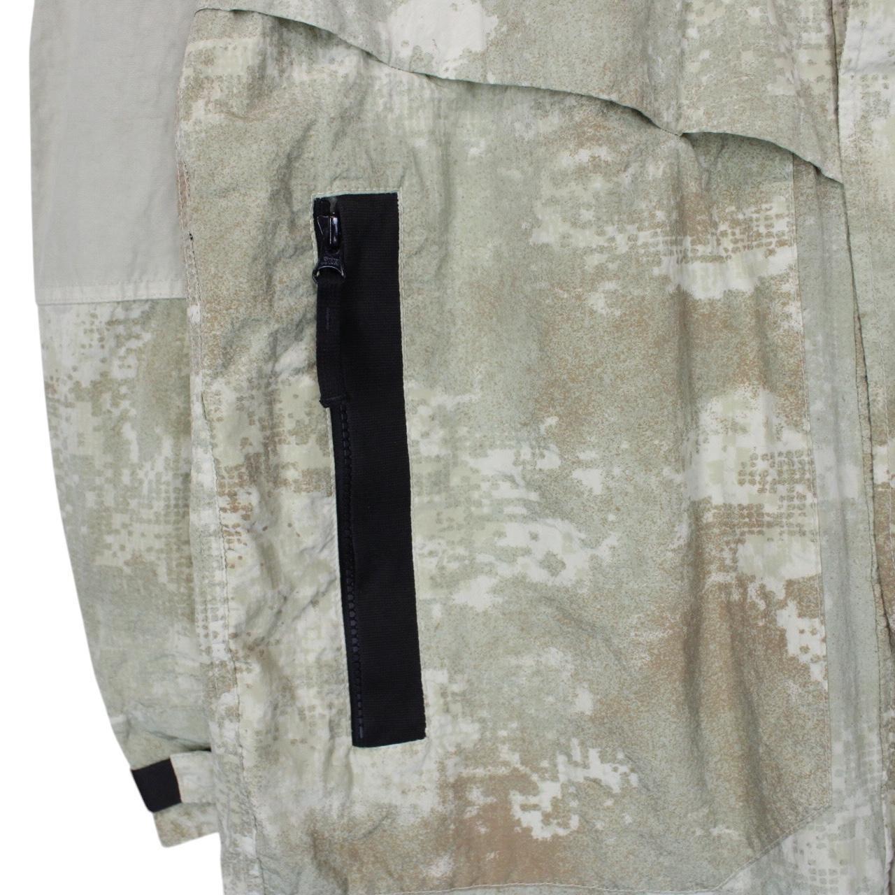 Stone Island green full zip jacket with dissolving grid camo pattern and logo patch.