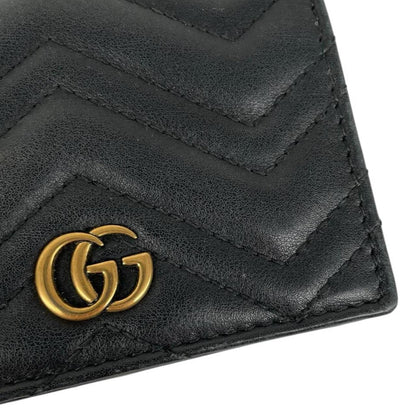 Gucci black calfskin wallet with matelassé pattern and GG logo detail.