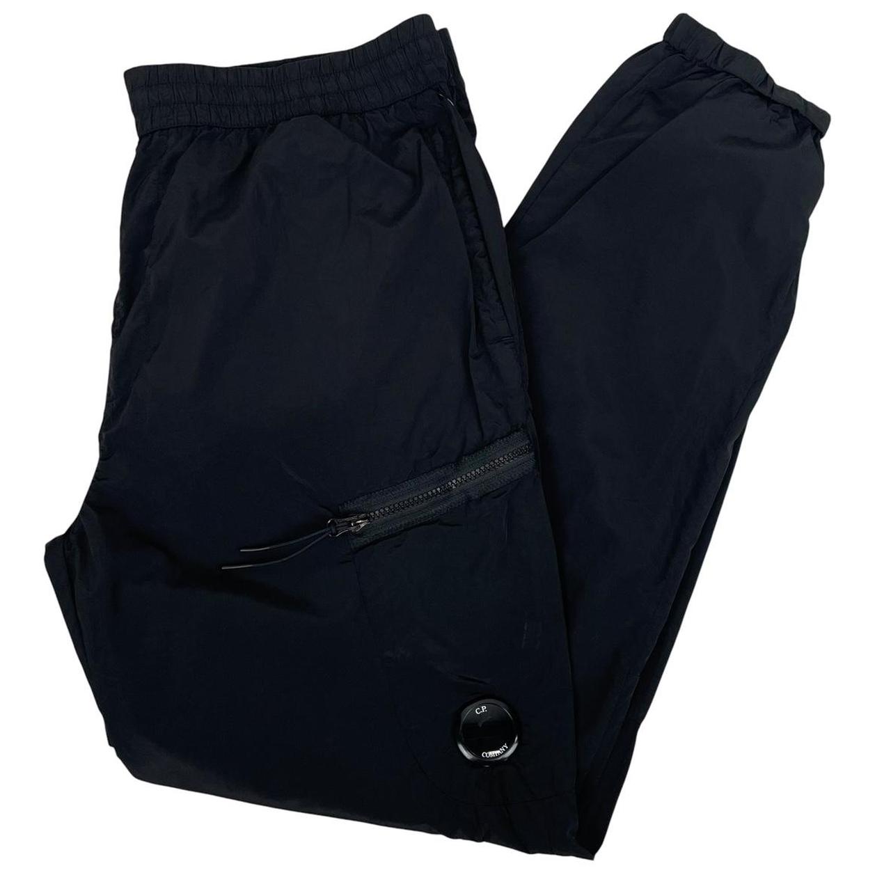 CP Company black cargo trousers with lens detail and nylon material.