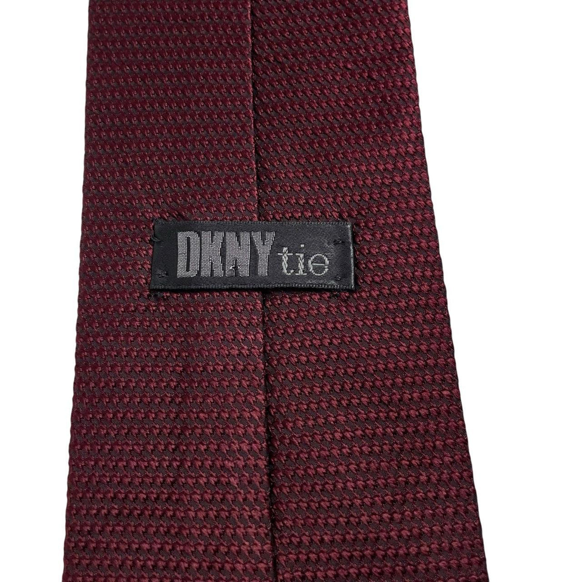 DKNY burgundy silk tie with subtle sheen and classic design.