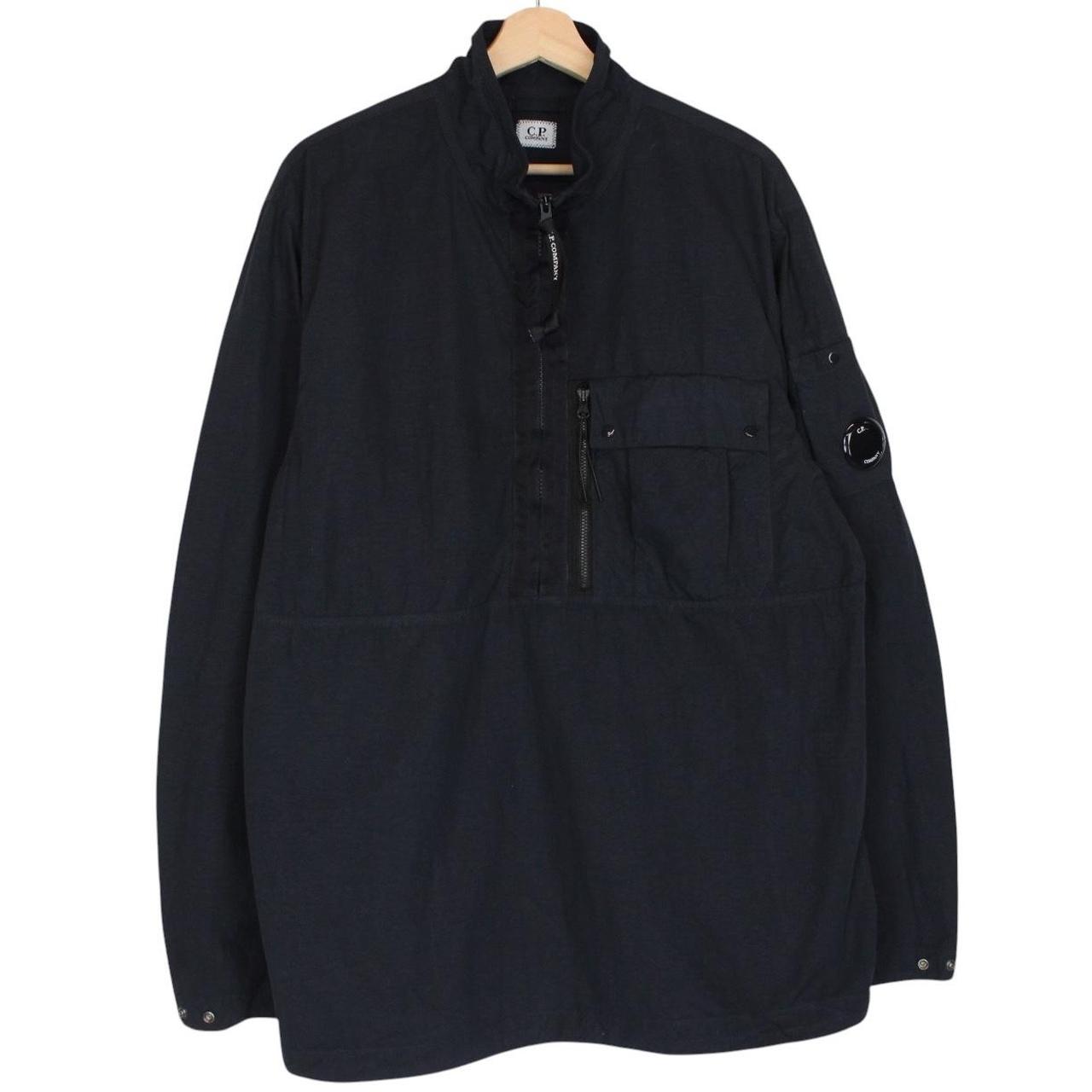 CP Company navy blue jacket 1/4 zip with lens detail and flat nylon material.