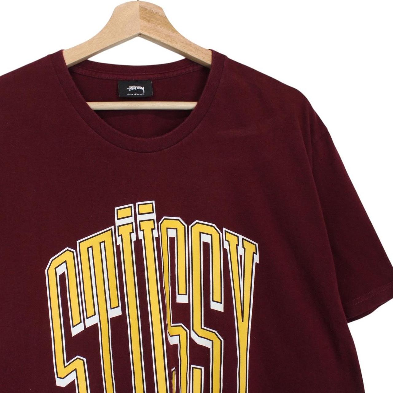 Stüssy burgundy pocket t-shirt with yellow college print and faint shoulder mark.