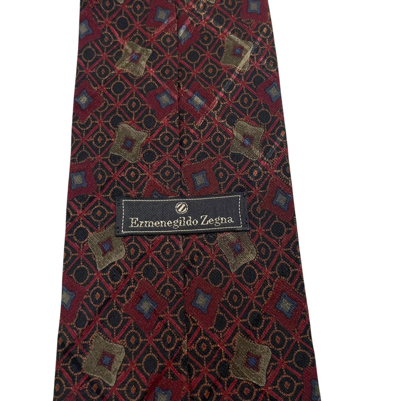 Ermenegildo Zegna burgundy silk tie with abstract print design and logo detail.