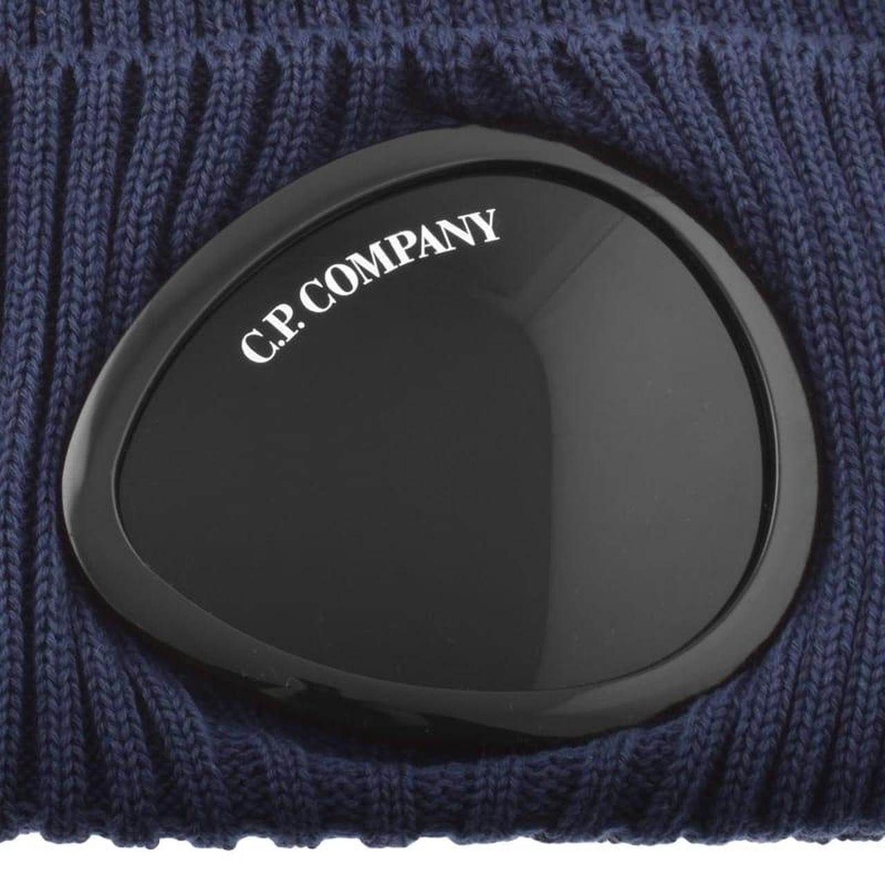 CP Company navy blue beanie hat with goggle detail and cotton material.