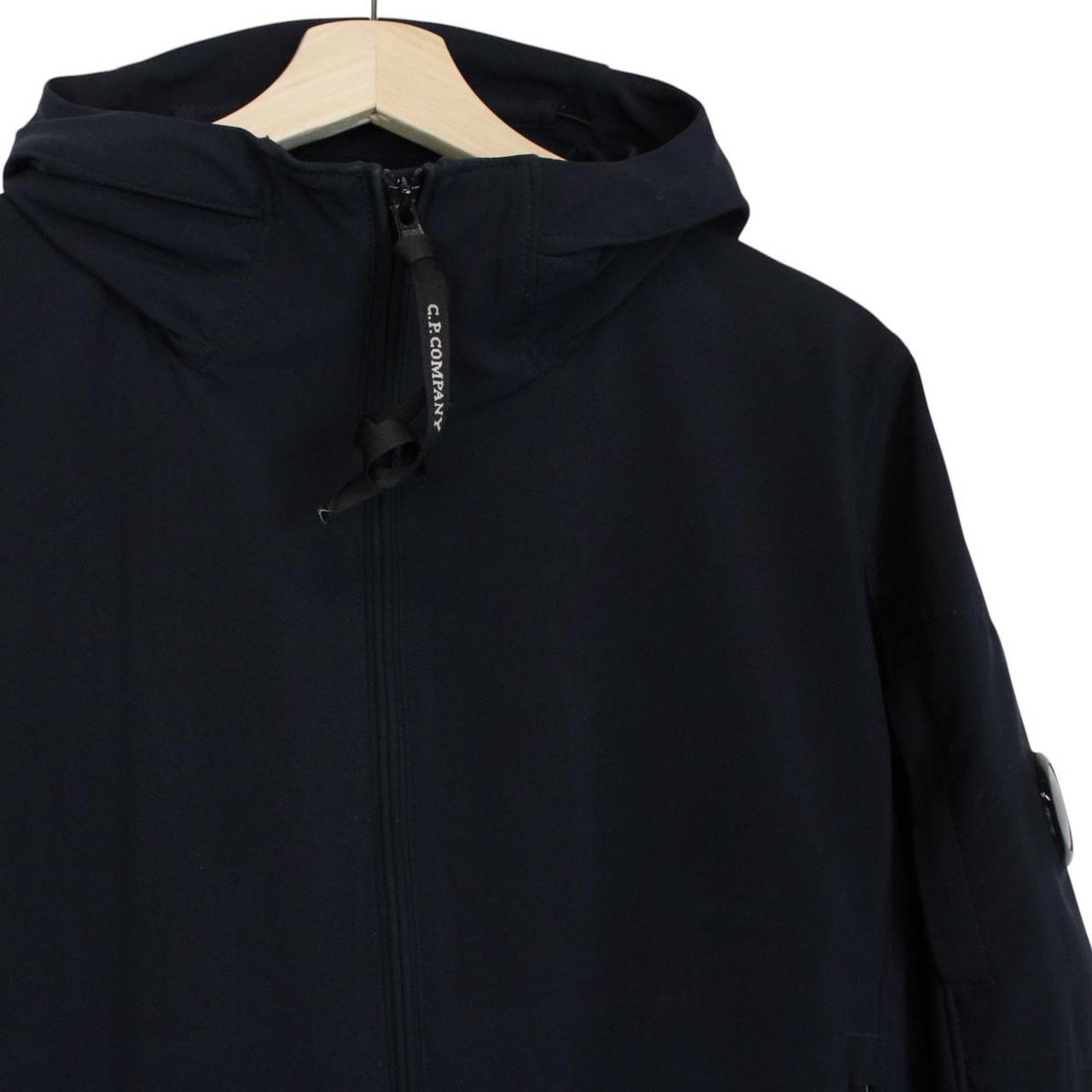 CP Company navy blue goggle jacket with full zip and soft shell material.