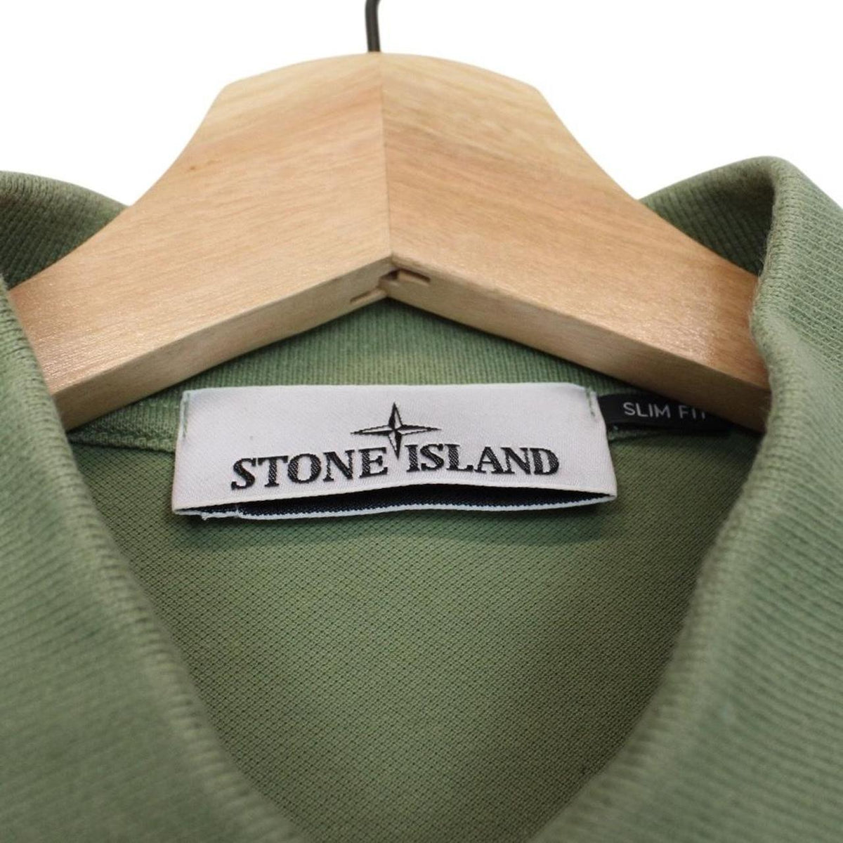 Stone Island green polo shirt with embroidered compass logo and cotton material.