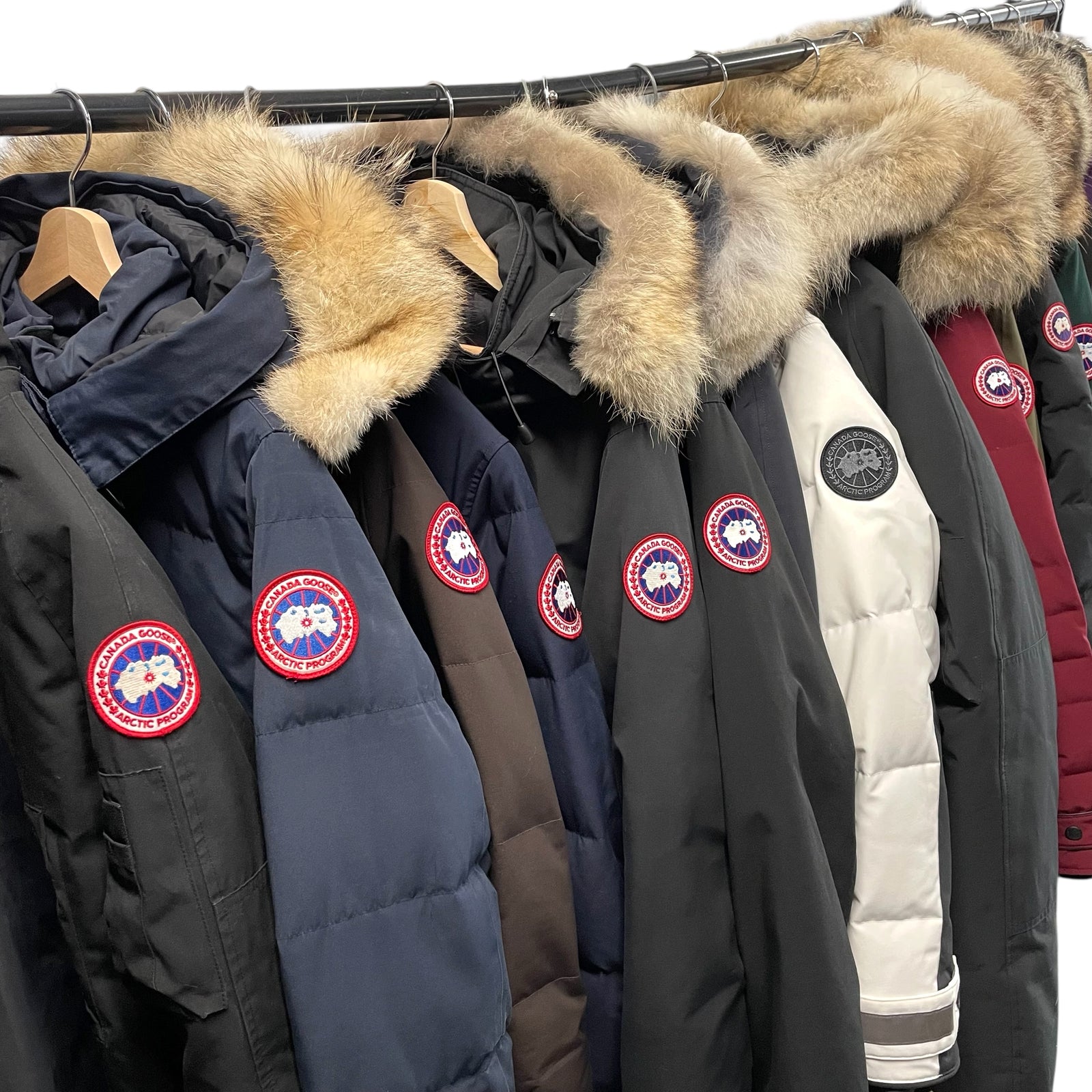  Row of Canada Goose jackets with fur hoods on a rack.
