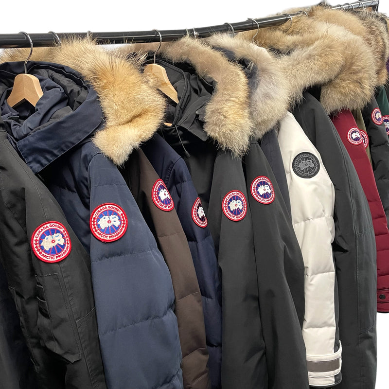  Row of Canada Goose jackets with fur hoods on a rack.